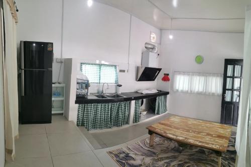 a kitchen with a black refrigerator and a table at KOMOWANAN HOMESTAY in Kundasang