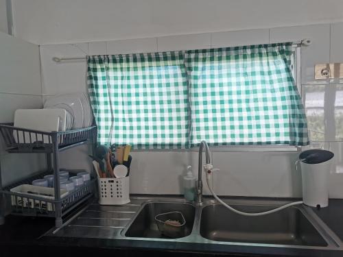 a kitchen counter with a sink and a window at KOMOWANAN HOMESTAY in Kundasang