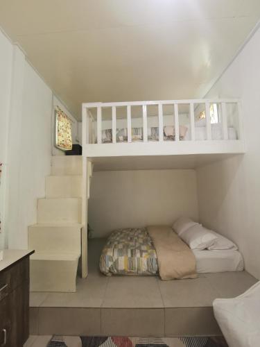 a small bedroom with a bunk bed and stairs at KOMOWANAN HOMESTAY in Kundasang