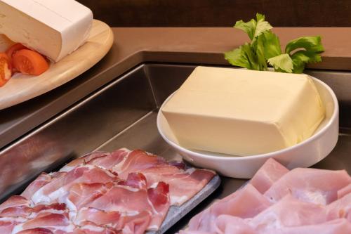 a tray of food with meat and cheese and vegetables at Hotel Pejo in Peio Fonti