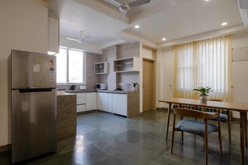 a kitchen with a stainless steel refrigerator and a table at C'est La Vie Boutique Apartments by Le Pension Stays in Jaipur