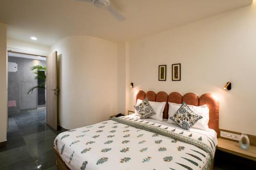 a bedroom with a large bed with a wooden headboard at C'est La Vie Boutique Apartments by Le Pension Stays in Jaipur