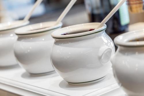 a row of white vases with wooden spoons in them at Hotel Pejo in Peio Fonti