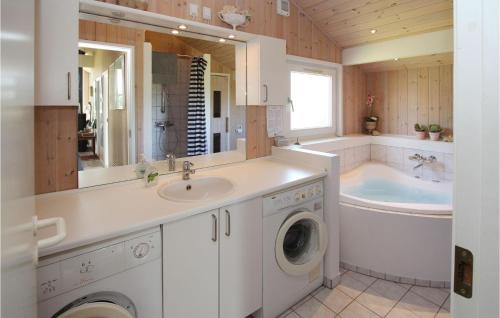 ein Badezimmer mit einem Waschbecken, einer Badewanne und einer Waschmaschine in der Unterkunft Stunning Home In Sams With Wifi in Onsbjerg