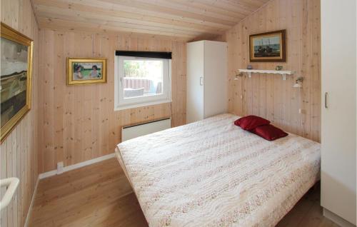 ein Schlafzimmer mit einem Bett in einem Zimmer mit Holzwänden in der Unterkunft Stunning Home In Sams With Wifi in Onsbjerg