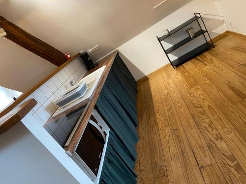 a kitchen with a sink and a wooden floor at Charmandy in Cany-Barville