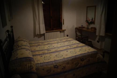 a bedroom with a bed with a blanket on it at Il Pozzo Della Citerna in Castelnuovo Berardenga