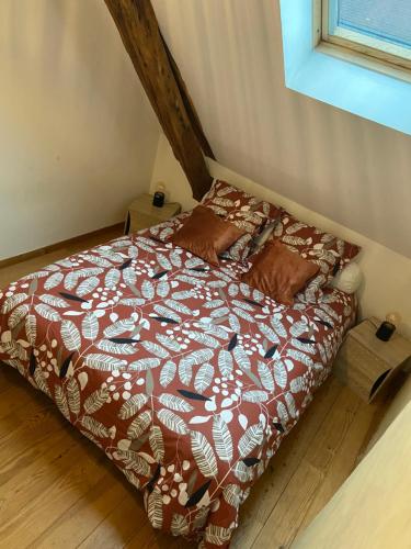 a bedroom with a bed with a brown and white comforter at Charmandy in Cany-Barville