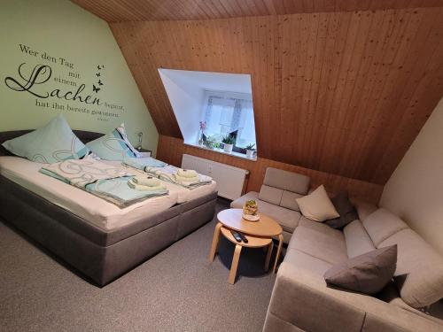 a room with two beds and a couch and a table at Pension Waldblick in Grillenberg