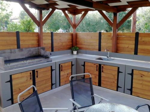 an outdoor kitchen with two chairs and a table at Villa Rêve in Nea Kallikrateia