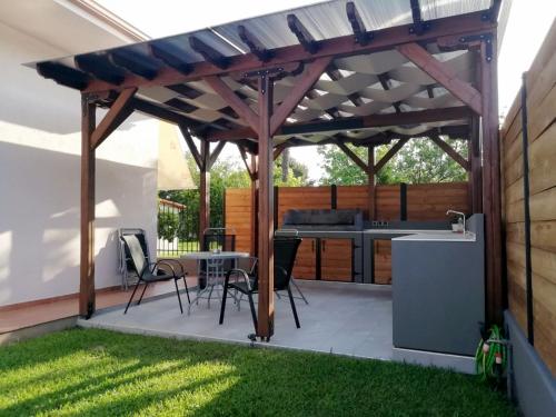 einen Pavillon mit einem Tisch und Stühlen auf einer Terrasse in der Unterkunft Villa Rêve in Nea Kallikratia