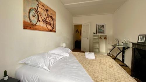 - une chambre avec un lit et un vélo suspendu au mur dans l'établissement L'occasion d'une pause, à Nevers
