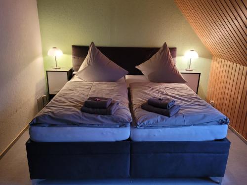 a bed in a room with two pillows on it at Pension Waldblick in Grillenberg