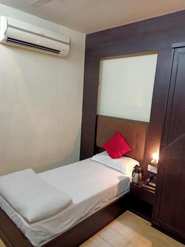 a bedroom with a bed with a red pillow on it at Hotel V.I.P. Regency in Dhanbād