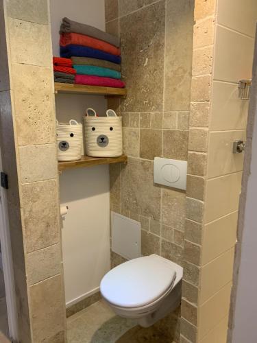 a bathroom with a toilet and some towels at Villa david in Grabels