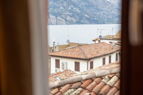 a view from a window of buildings and the water at Hotel Lago Di Garda in Malcesine
