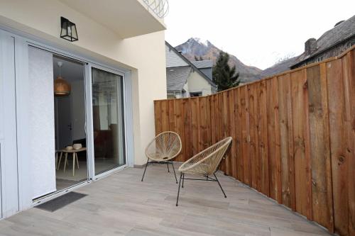two chairs sitting on a patio with a fence at La parenthèse du Tourmalet - séjour tout compris - draps et ménage inclus- in Luz-Saint-Sauveur