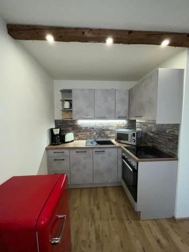 a small kitchen with stainless steel appliances and a red bench at Gasthof Zum Ott in Staudach-Egerndach