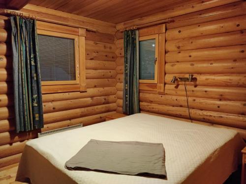 um quarto com uma cama num chalé de madeira em Topin Mestari Ruka em Ruka