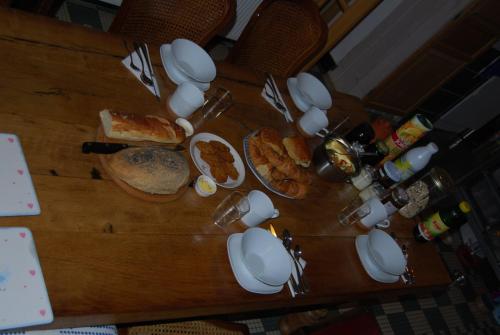 a wooden table with breakfast foods and drinks on it at Auberge St P Vegetarien BnB in Saint-Pastous