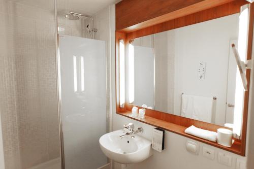 a bathroom with a sink and a shower and a mirror at Campanile Melun Sud - Dammarie les Lys in Melun