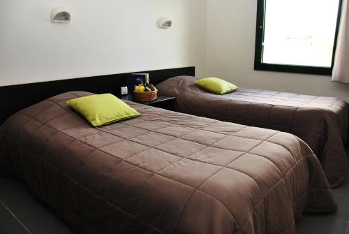 2 camas con almohadas verdes en una habitación en Le Cap d'Opale, en Ambleteuse