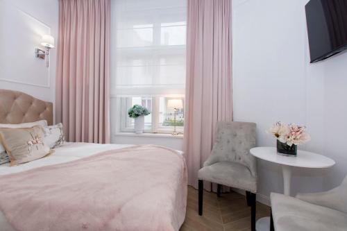 1 dormitorio con cama, mesa y ventana en La Boutique Studio Sopot, en Sopot