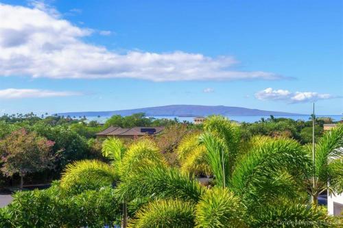 a view of a resort with palm trees and the ocean at Tiki Tiki - Gorgeous Boho Beach Hideaway! in Wailea