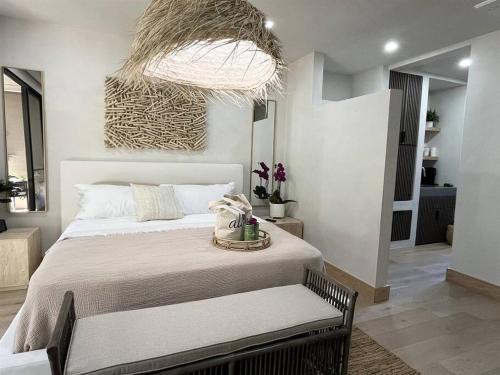 Tiki Tiki - Gorgeous Boho Beach Hideaway! في ويليا: غرفة نوم بسرير كبير وثريا كبيرة
