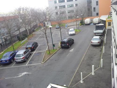 a bunch of cars parked in a parking lot at ibis Budget Gennevilliers Asnieres in Gennevilliers