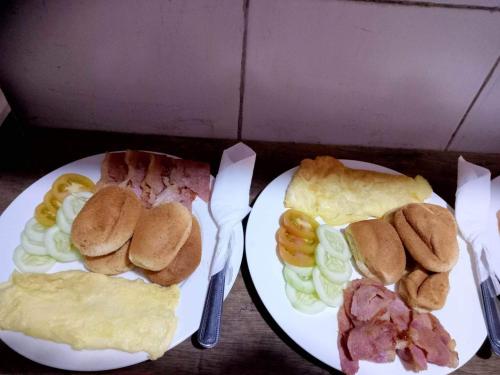 two white plates of food with sandwiches and meat at Sang Yoo Mountain View Tagaytay Bed and Breakfast - Taal Lake View in Tagaytay