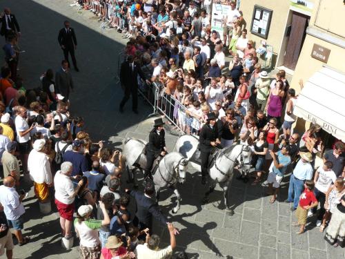 a crowd of people watching two police officers on horses at Il Pozzo Della Citerna in Castelnuovo Berardenga