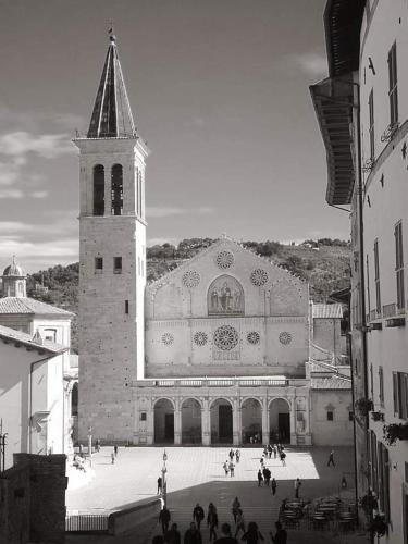 a black and white photo of a building with a clock tower at Appartamento di Via Refini in Spoleto
