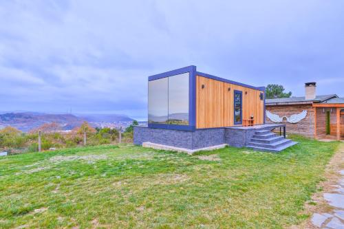 a house on a hill with a glass wall at Agva Teras Garden Hotel & Bungalow in Agva