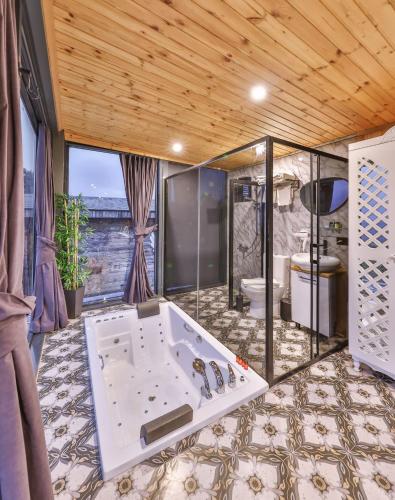 a large bathroom with a tub in the middle of a room at Agva Teras Garden Hotel & Bungalow in Agva