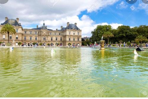 een groot paleis met een vijver ervoor bij Vavin luxembourg garden in Parijs