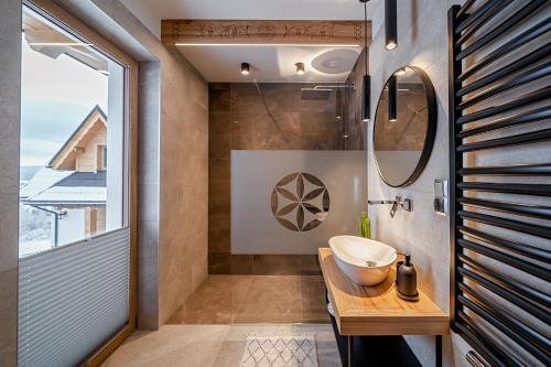 a bathroom with a sink and a mirror at Osada Wichrówka in Dursztyn