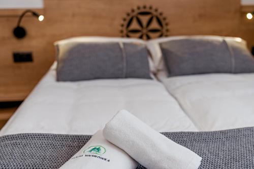 a white bed with two pillows on top of it at Osada Wichrówka in Dursztyn
