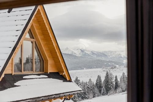 a cabin with a view of a snowy mountain at Osada Wichrówka in Dursztyn