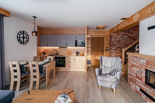 a kitchen and living room with a brick wall at Osada Wichrówka in Dursztyn