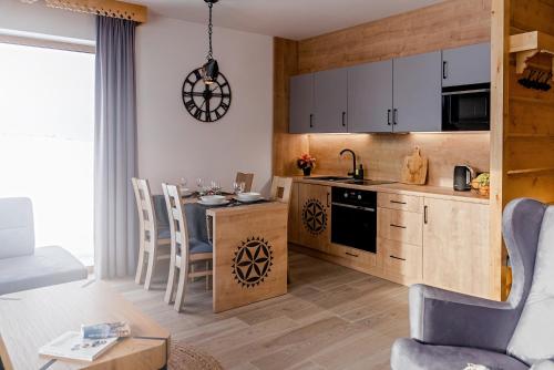 a kitchen and living room with a table and chairs at Osada Wichrówka in Dursztyn