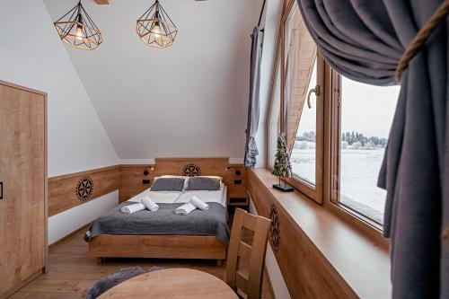a bedroom with a bed and a window at Osada Wichrówka in Dursztyn
