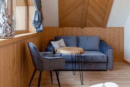 a living room with a blue couch and a table at Osada Wichrówka in Dursztyn