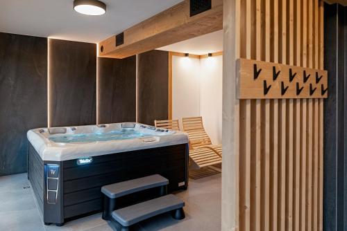a jacuzzi tub in a room with a wooden wall at Osada Wichrówka in Dursztyn