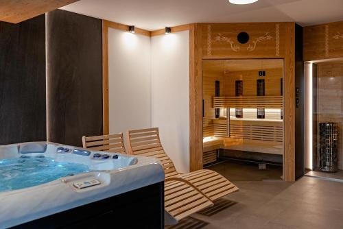 a bathroom with a tub and a chair in a room at Osada Wichrówka in Dursztyn