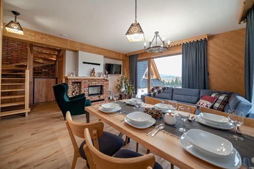 a dining room and living room with a table and chairs at Osada Wichrówka in Dursztyn