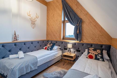a bedroom with two beds and a window at Osada Wichrówka in Dursztyn