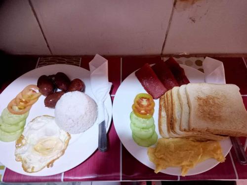 a table with two plates of breakfast food on it at Sang Yoo Mountain View Tagaytay Bed and Breakfast - Taal Lake View in Tagaytay