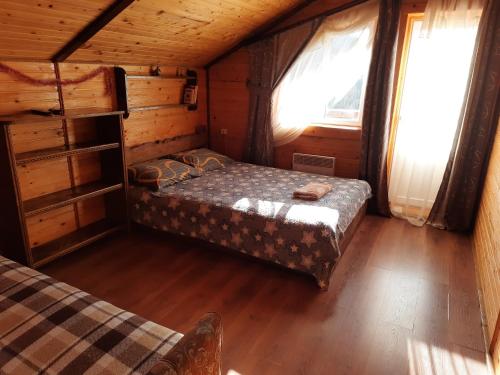 a bedroom in a cabin with a bed and two windows at Котедж Віадук in Vorokhta