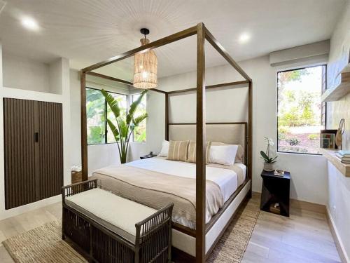 1 dormitorio con cama con dosel y ventana en Aloha Moon - A Chic and Dreamy Modern Tropical Hideaway! en Wailea